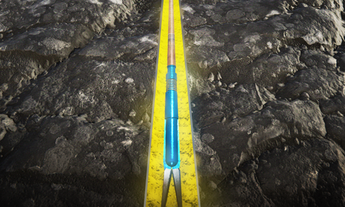 Un apero de labranza con un mango azul y un extremo en forma de horquilla aparece en un surco con líneas amarillas en un campo de tierra.