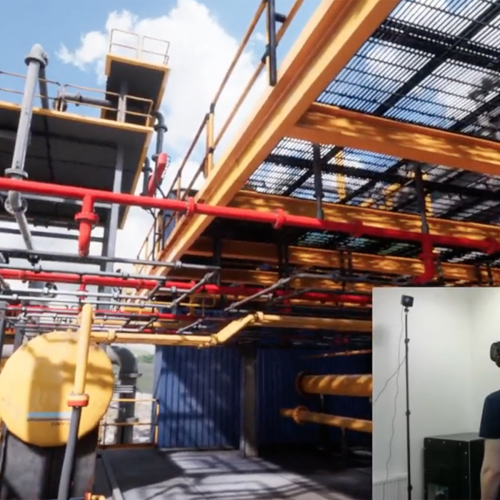A person wearing a VR headset is immersed in a virtual industrial environment showcasing machinery, yellow tanks, and red pipelines.