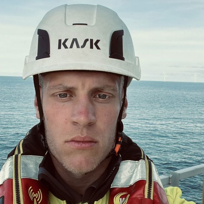 selfie of a man offshore with wind turbines
