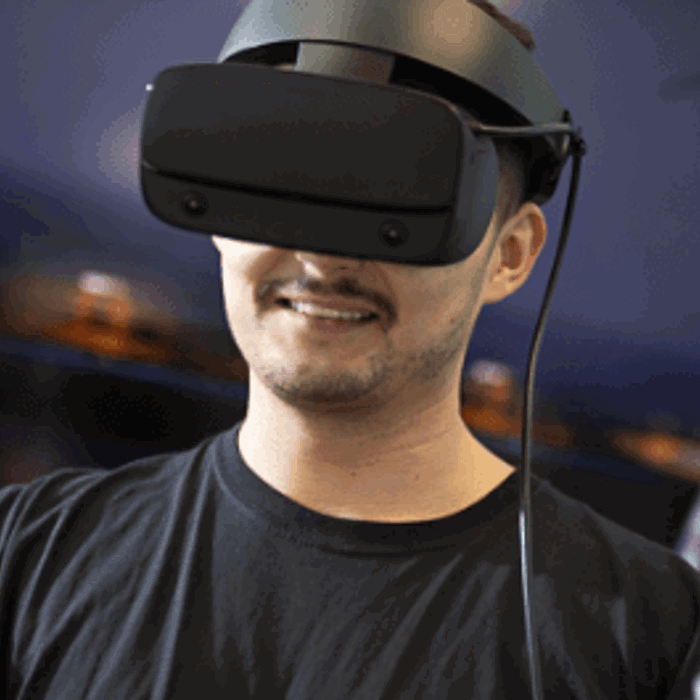 A man wearing a virtual reality headset and holding controllers in both hands.
